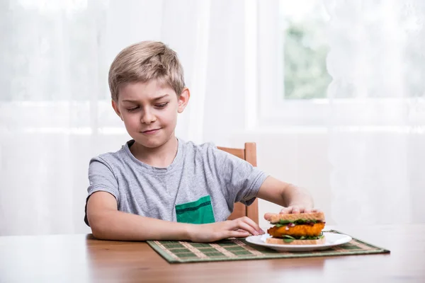 Fussy kid with chicken sandwich — Stock Photo, Image