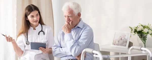 Paziente che parla con un giovane medico — Foto Stock