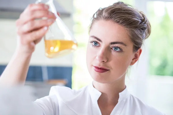 Female chemist holding flask — Stock Photo, Image