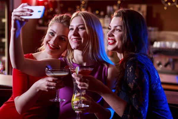 Girls taking selfie at bar