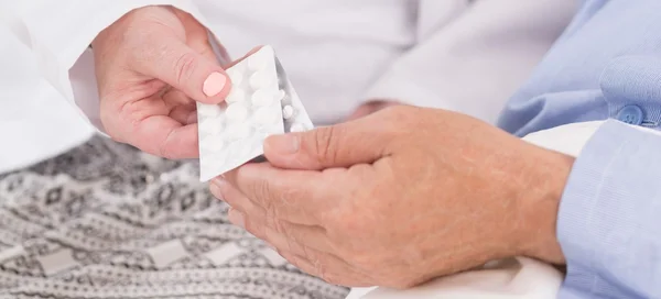 Sjuksköterska ger blister tabletter — Stockfoto