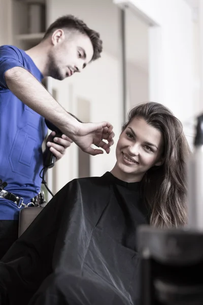 Coiffeur séchant les cheveux de femme — Photo