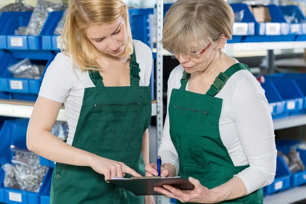 Mujeres comprobando la lista de productos — Foto de Stock