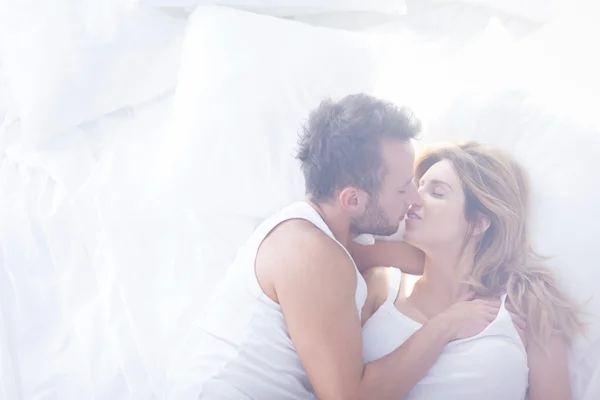 Amantes románticos besándose en la cama — Foto de Stock