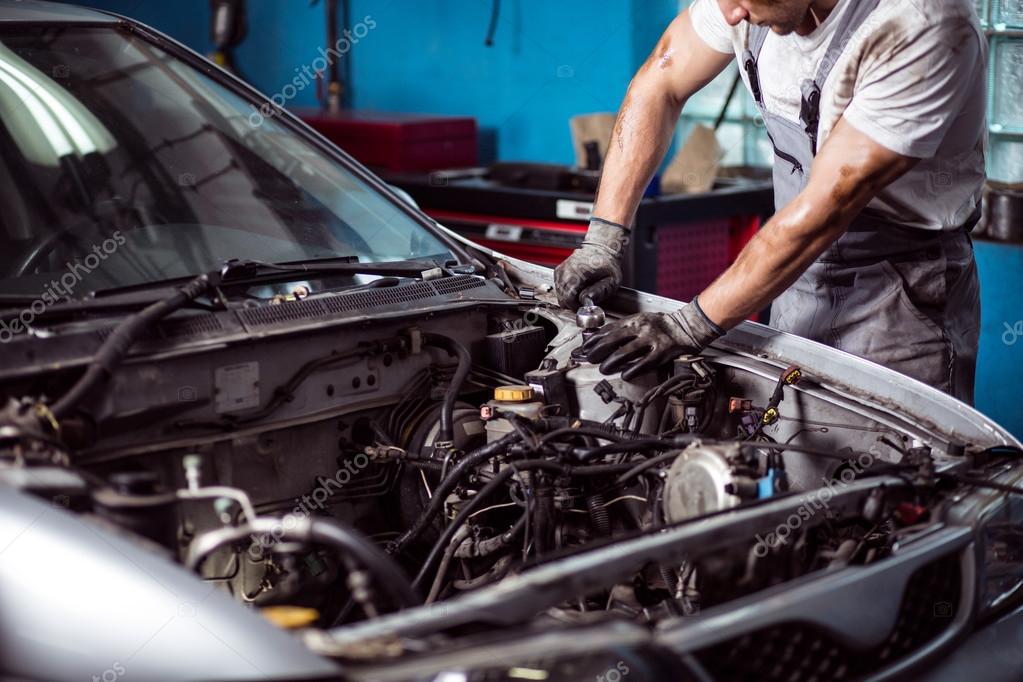Mechanic maintaining car engine Stock Photo by ©photographee.eu 81166330