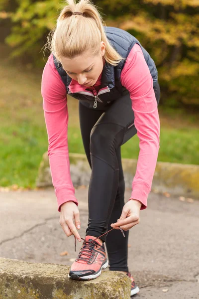 Deportiva mujer atando sus zapatos — Foto de Stock