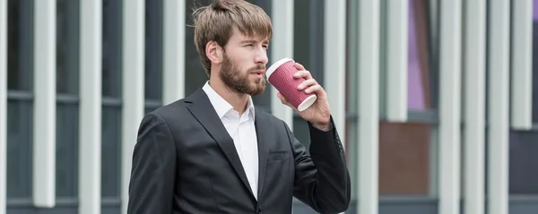 Schöner junger Chef trinkt Kaffee — Stockfoto