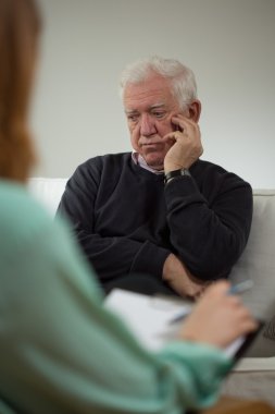 Sad man talking with psychiatrist clipart