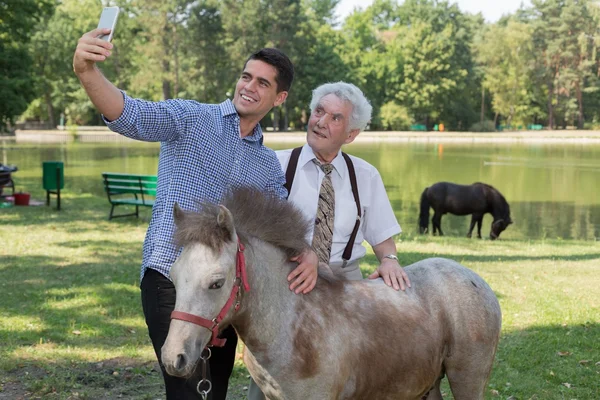 Man taking selfie with grandfather — Stock Photo, Image