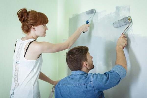Couple painting wall together