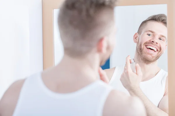 Lächelnder Mann, der sein Spiegelbild bewundert — Stockfoto