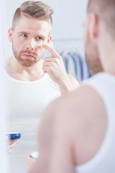 Bien kempt hombre aplicando crema — Foto de Stock