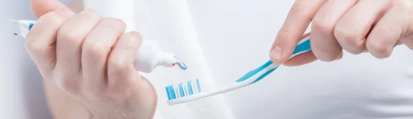 Male hands applying tooth paste — Stock Photo, Image