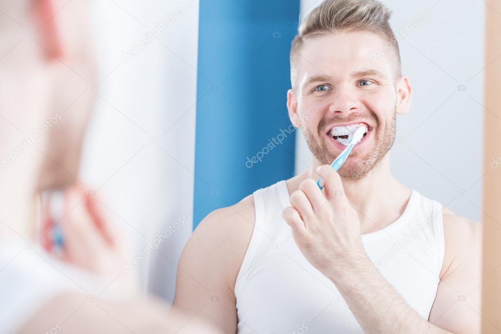 Narcissistic male brushing teeth