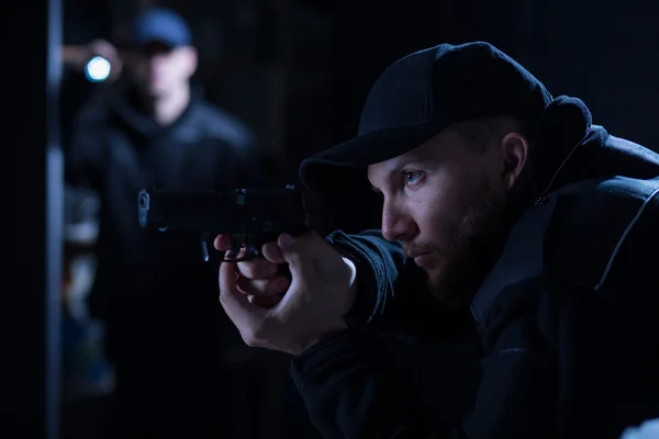 Policial segurando arma — Fotografia de Stock