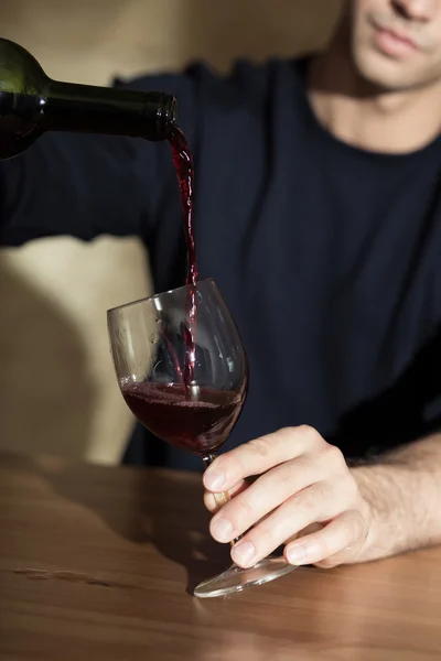 Homem derramando vinho tinto — Fotografia de Stock