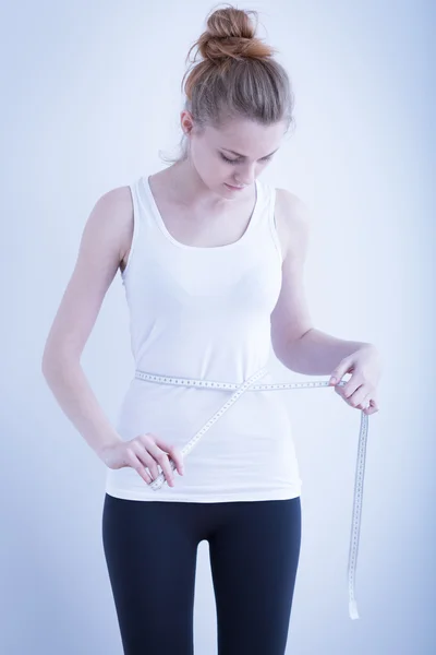Skinny girl measuring waist — Stok fotoğraf