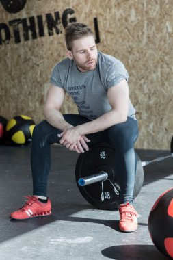 Weightlifter sitting on the barbell