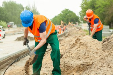 Construction workers digging