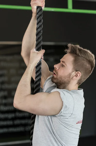 Homem escalando a corda — Fotografia de Stock