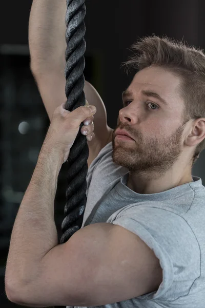 Sexy strongman climbing the rope — Stockfoto