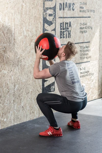 Hombre entrenando con pelota de ejercicio — Foto de Stock