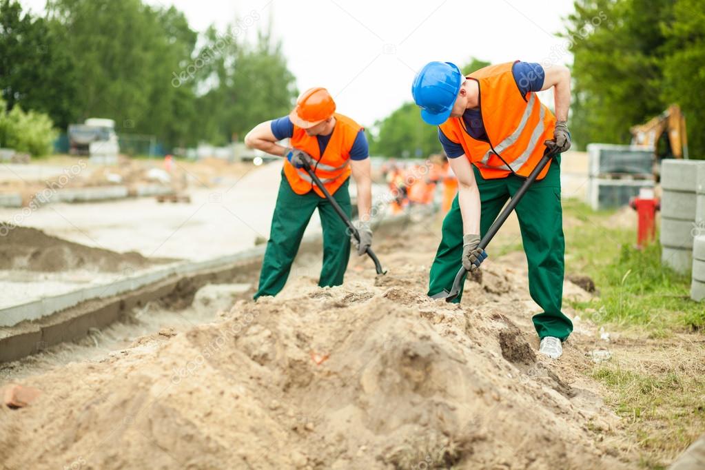 Construction workers digging