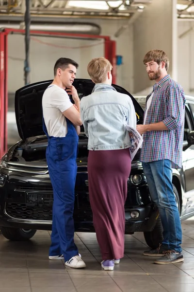 Coppia presa con meccanico auto — Foto Stock