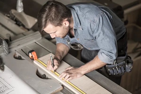 Carpenter using a measuring tape — Stock Photo, Image