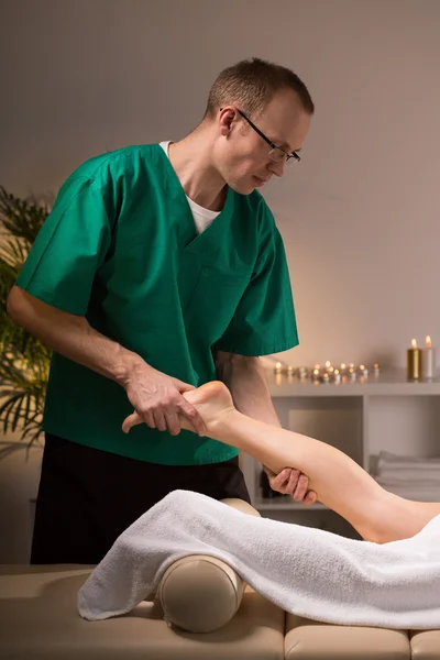 Fisioterapeuta massageando perna feminina — Fotografia de Stock