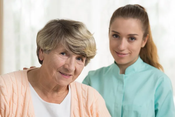 Lachende senior vrouw en verpleegkundige — Stockfoto