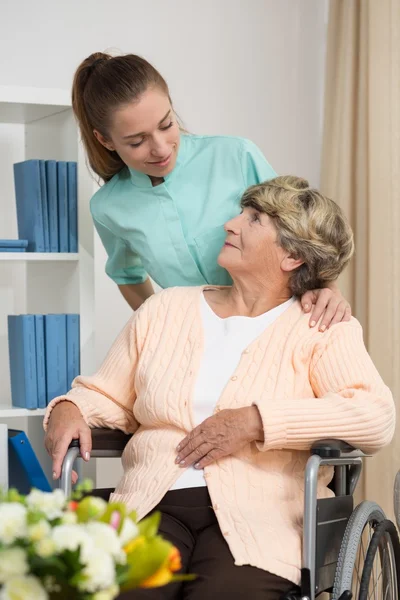 Жінка з обмеженими можливостями розмовляє з медсестрою — стокове фото