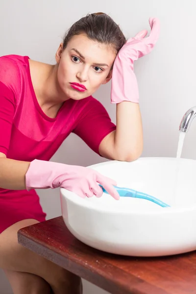 Femme ennuyée nettoyage lavabo — Photo