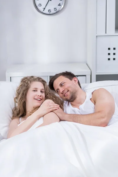 Happy couple lying in bed — Stock Photo, Image