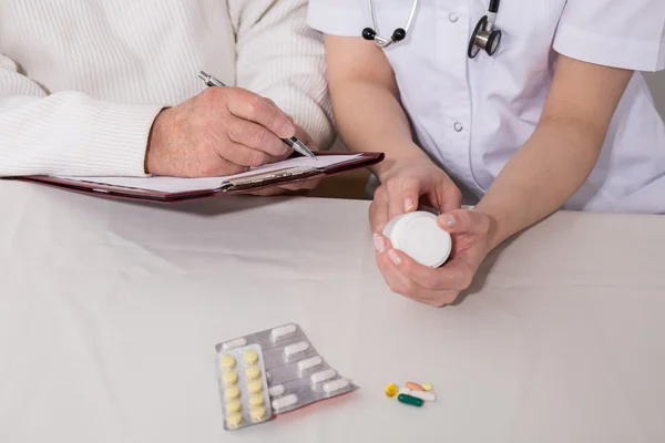 Patient writing dosage of medicines — Stock Photo, Image