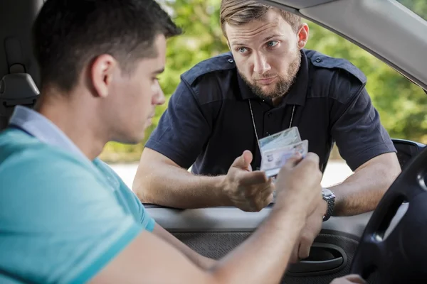 Policeman checking documents — Stock Photo, Image