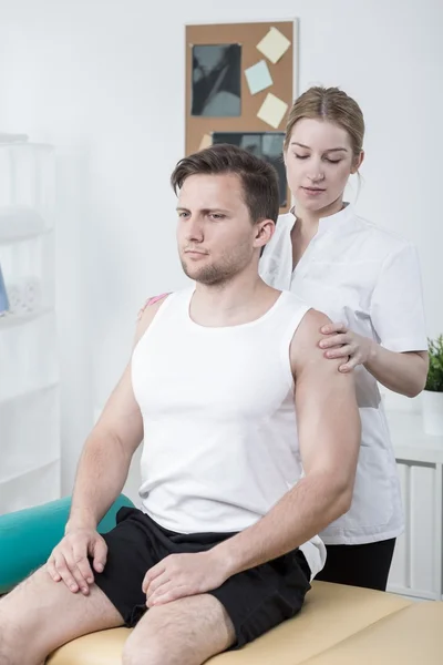 Terapeuta examinando homem atlético — Fotografia de Stock