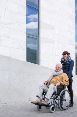 Bir tekerlekli sandalye iterek kıdemli asistan