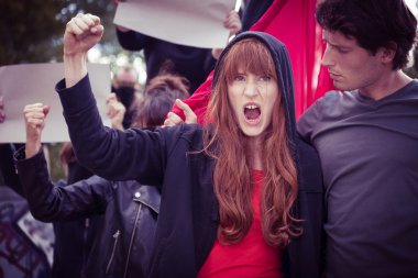 Yükseltilmiş yumruk ile kadın protestocu