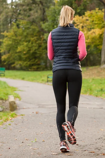 Frau joggt im Herbst im Park — Stockfoto