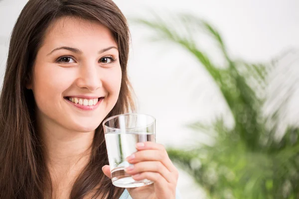 Подходящая девушка, пьющая минеральную воду — стоковое фото