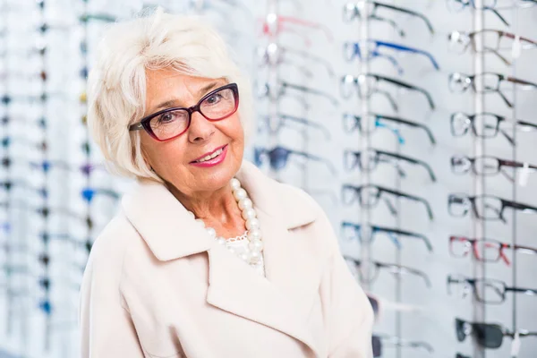 Ältere Frau probiert Brille an — Stockfoto