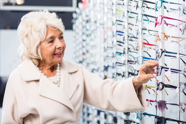 Mujer mayor comprando gafas graduadas — Foto de Stock