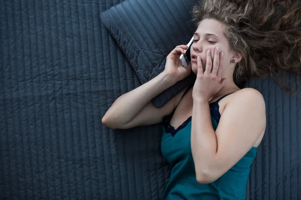 Sleepy female talking on phone — Stock Photo, Image