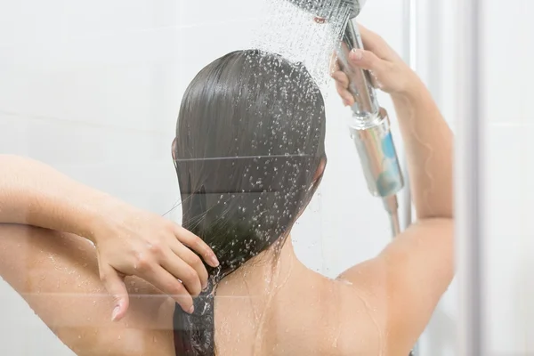 Девушка моет волосы под душем — стоковое фото
