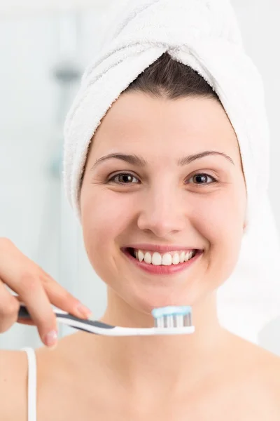 Sonriente hembra cepillándose los dientes — Foto de Stock