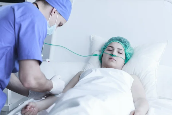 Surgeon injecting ill woman — Stock Photo, Image