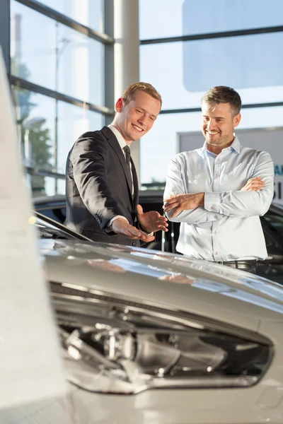 Smiling car salesman with customer — Stock Photo, Image