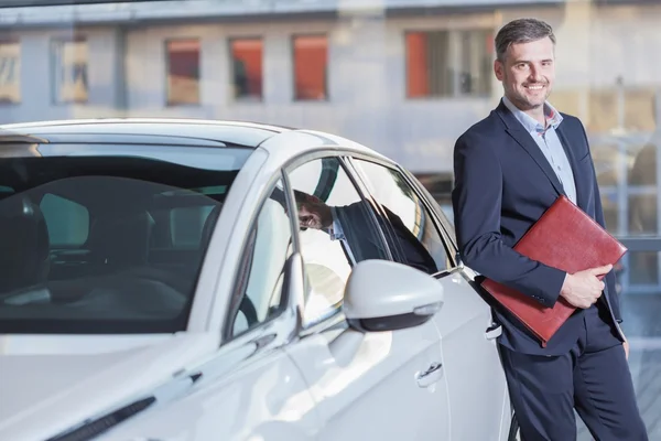 Lächelnder Geschäftsmann mit neuem Auto — Stockfoto