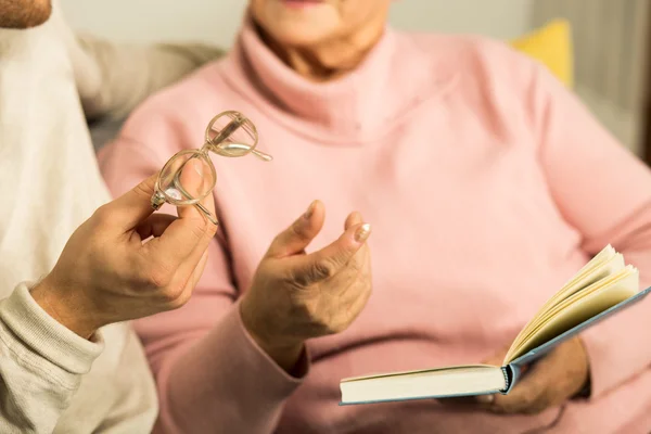 Seniorin Lesebrille geben — Stockfoto